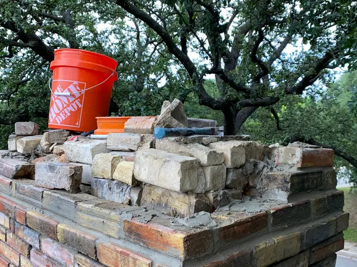 Brick chimney being rebuilt course by course