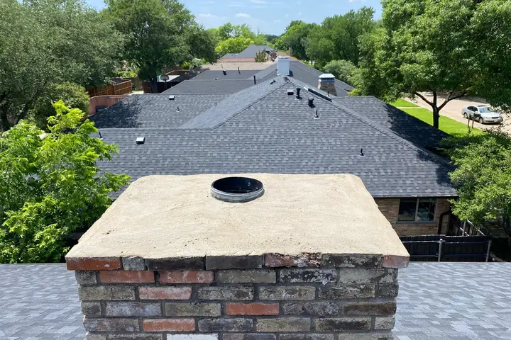 Freshly rebuilt concrete chimney crown on a brick chimney