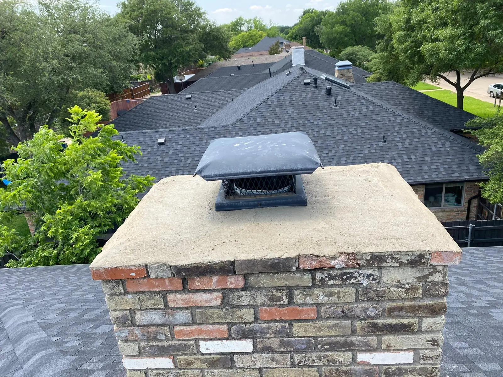 New chimney cap installed by the Crownline Chimney Sweep crew on a brick chimney in a Arlington-area neighborhood